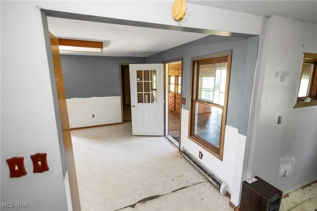 Doorway to outside with baseboard heating and baseboards