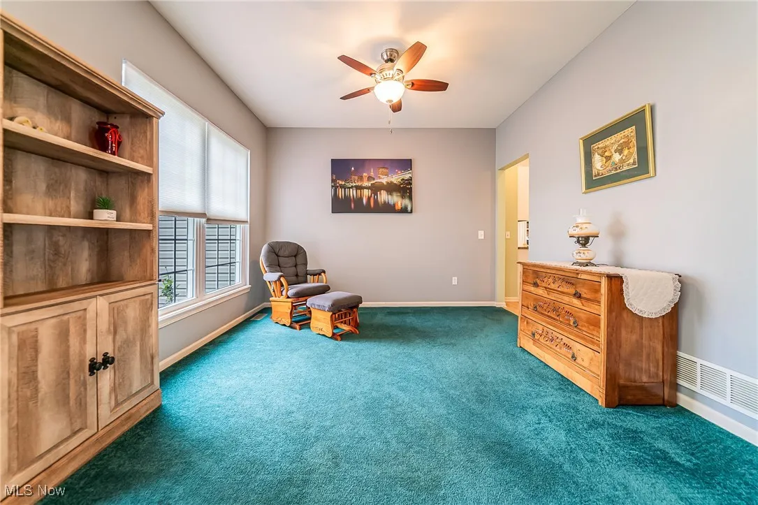 Sitting room featuring carpet and a ceiling fan
