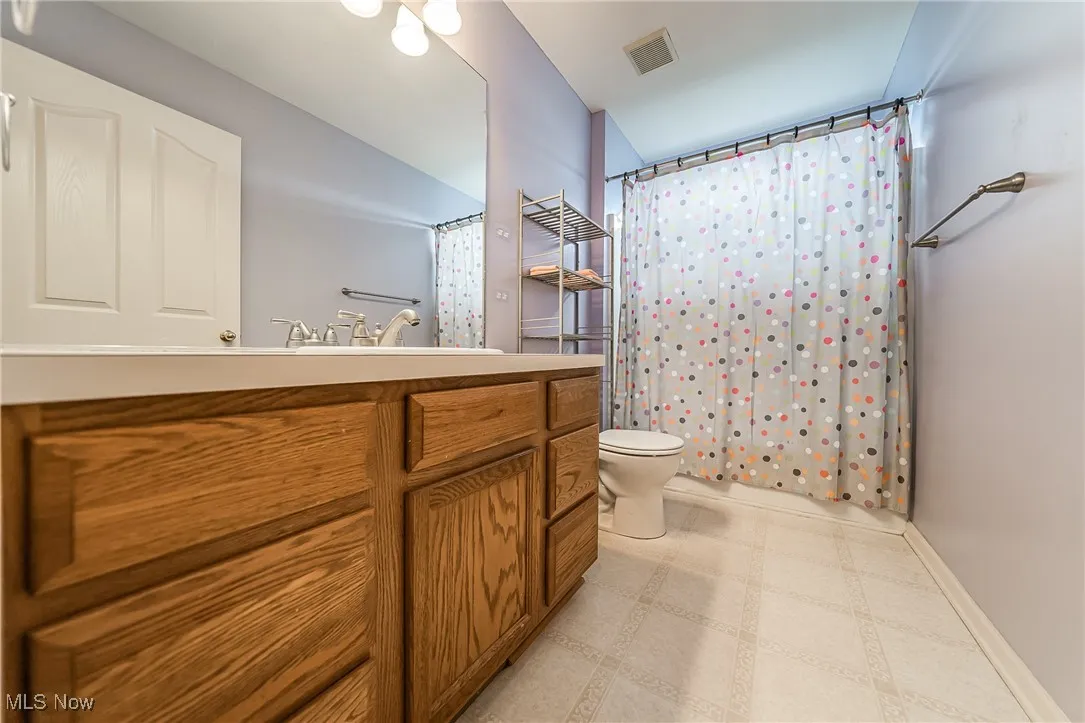 Bathroom featuring tile patterned floors, vanity, and a shower with shower curtain