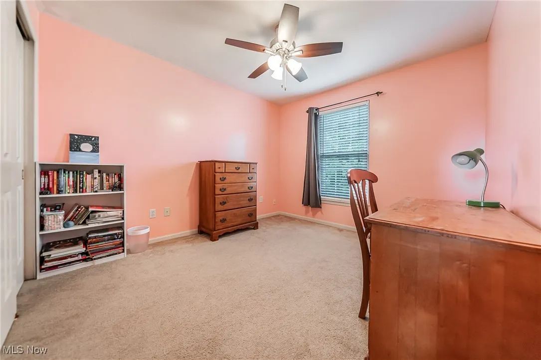 Office space featuring light colored carpet and a ceiling fan