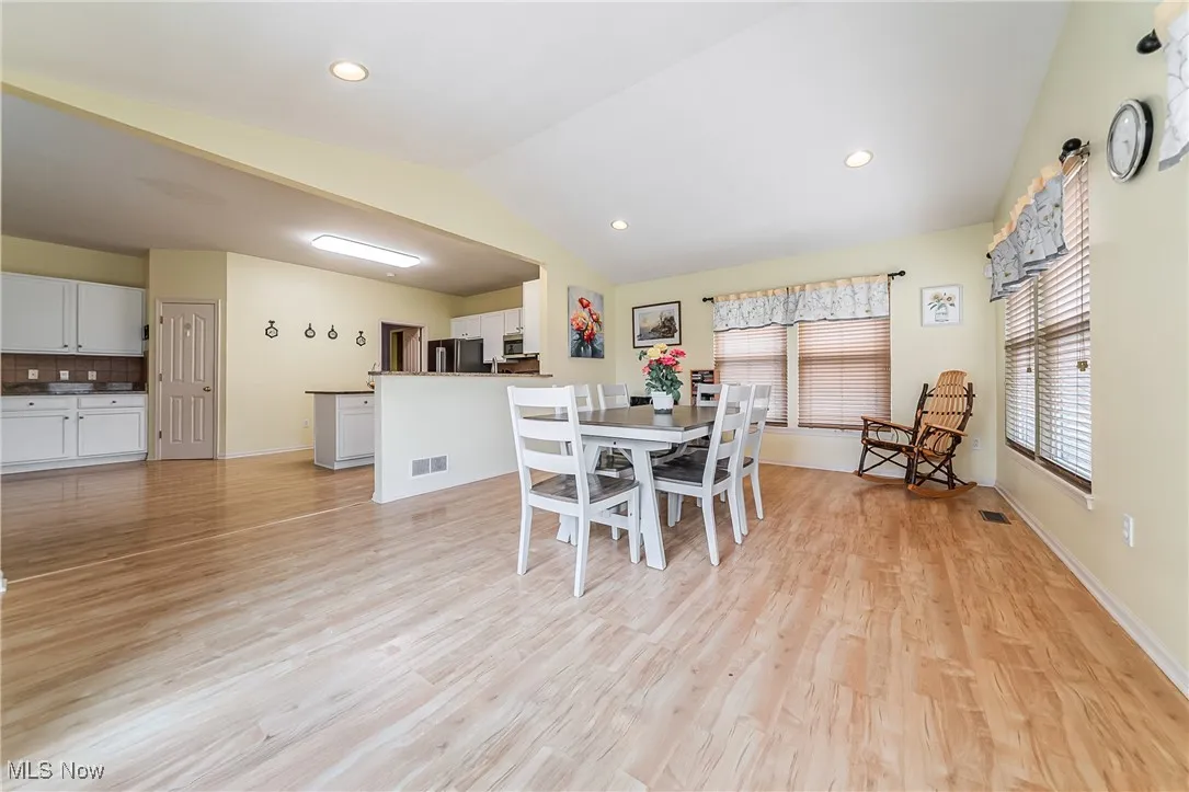 Dining room featuring vaulted ceiling, light wood-type flooring, and recessed lighting