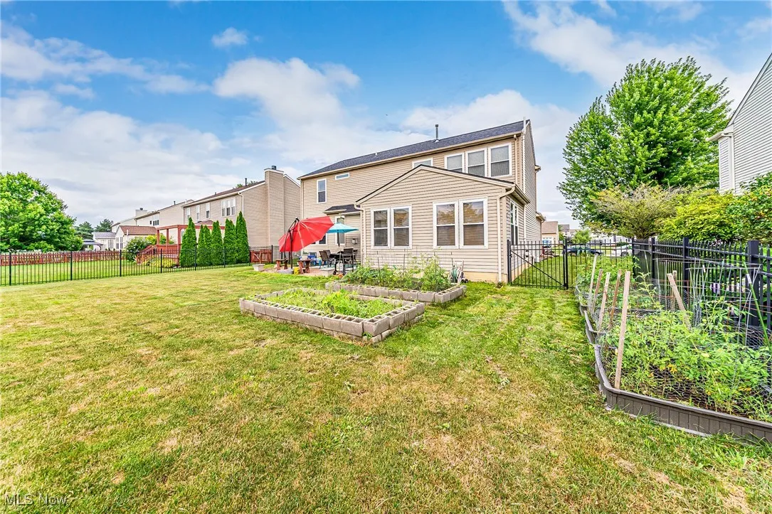 Rear view of property featuring a garden and a fenced backyard