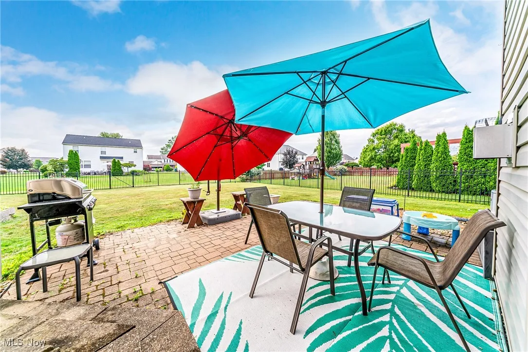 Fenced backyard featuring outdoor dining area, a patio area, and grilling area