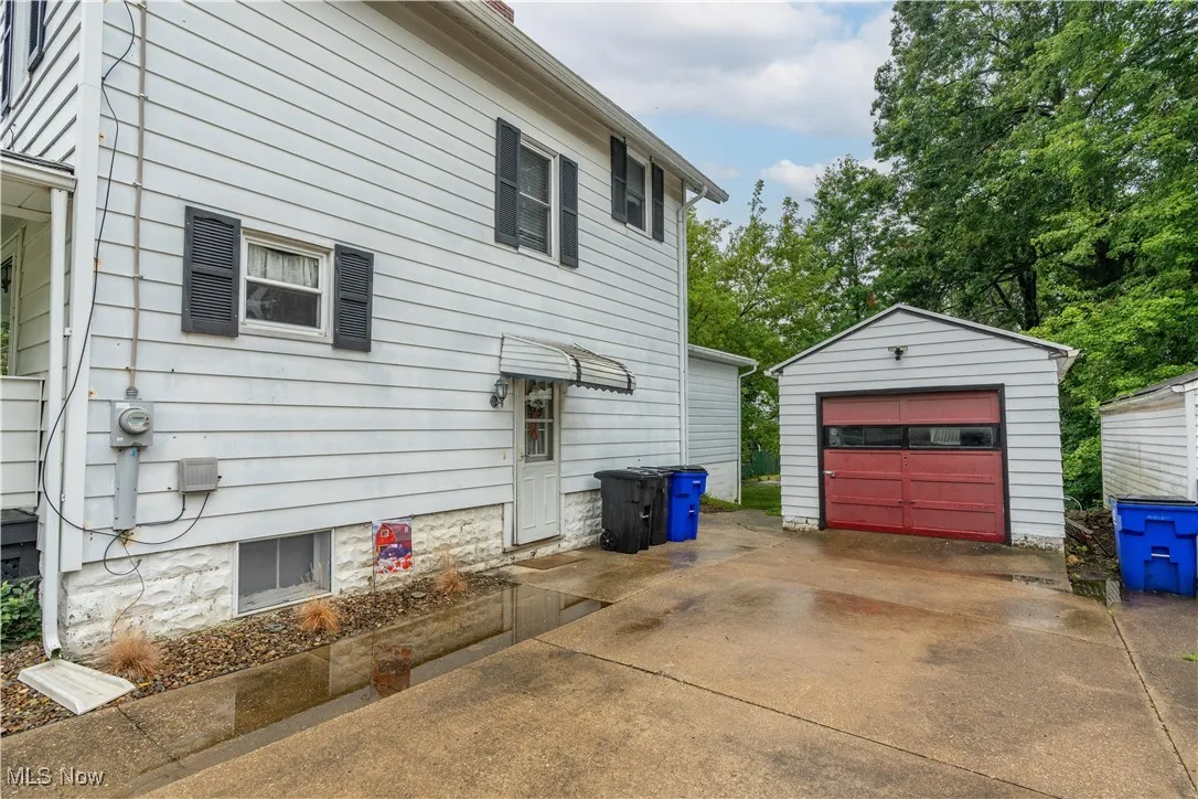 View of home's exterior with concrete driveway, an outdoor structure, and a garage