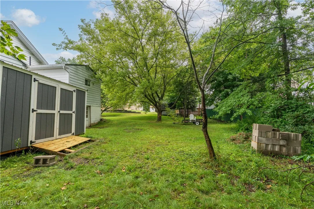 View of grassy yard featuring a storage shed