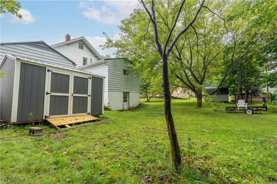 View of green lawn featuring a shed