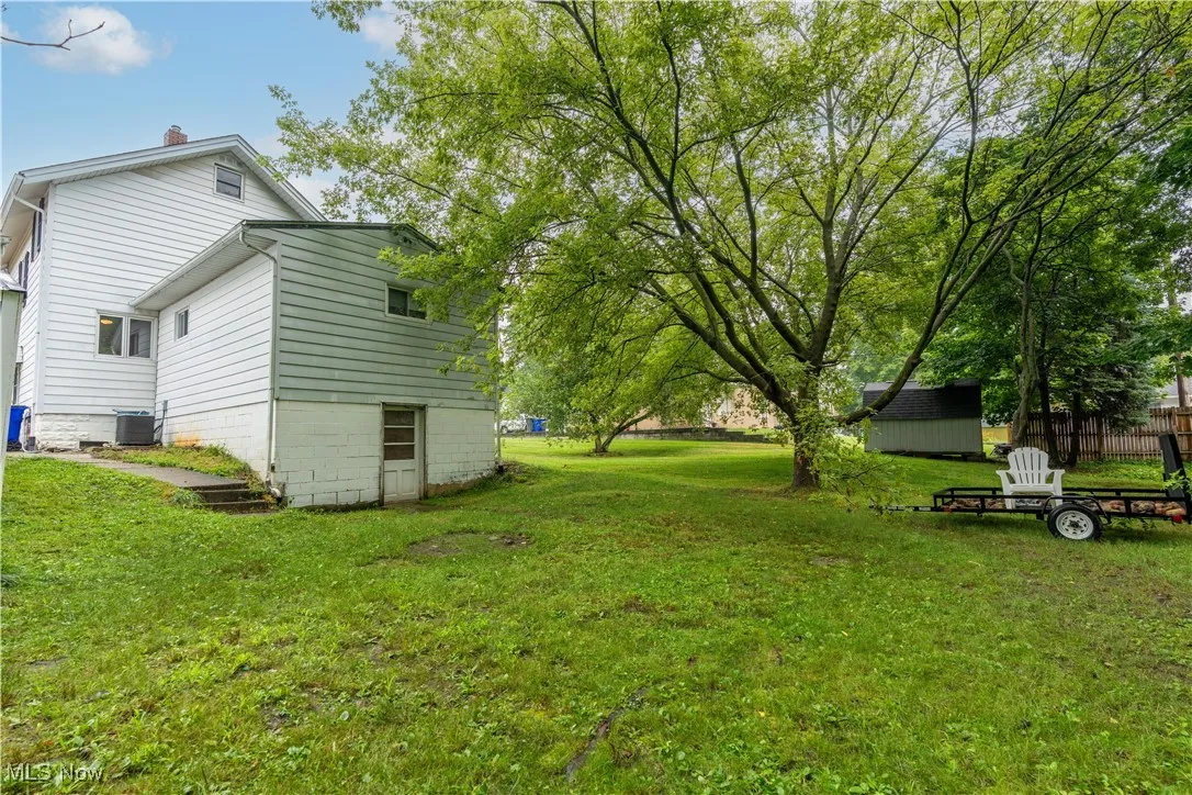 View of green lawn with a storage shed