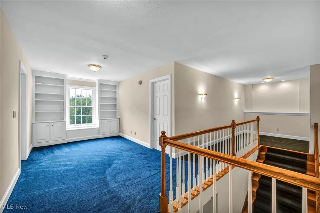 Hall with an upstairs landing, carpet, and built in features