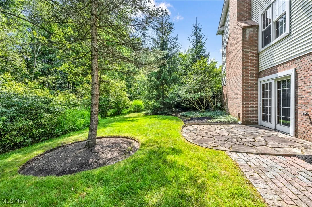 View of green lawn with a patio area
