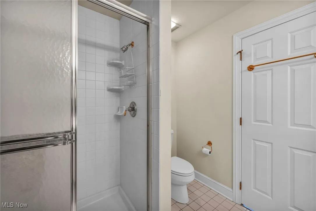 Full bathroom with a stall shower and tile patterned flooring
