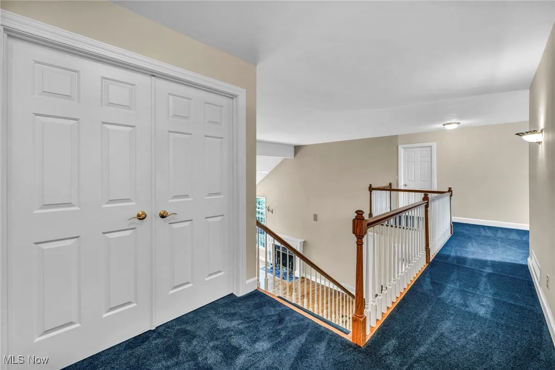 Hallway featuring an upstairs landing and carpet floors