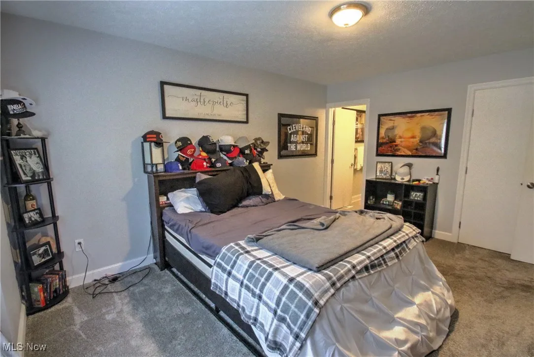 Carpeted bedroom featuring baseboards and a textured ceiling