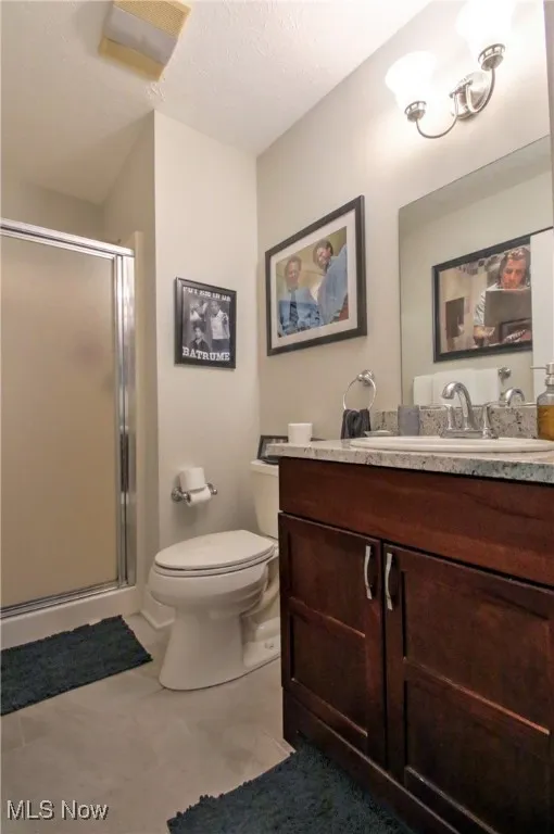 Master Bathroom featuring a textured ceiling, vanity, and a stall shower