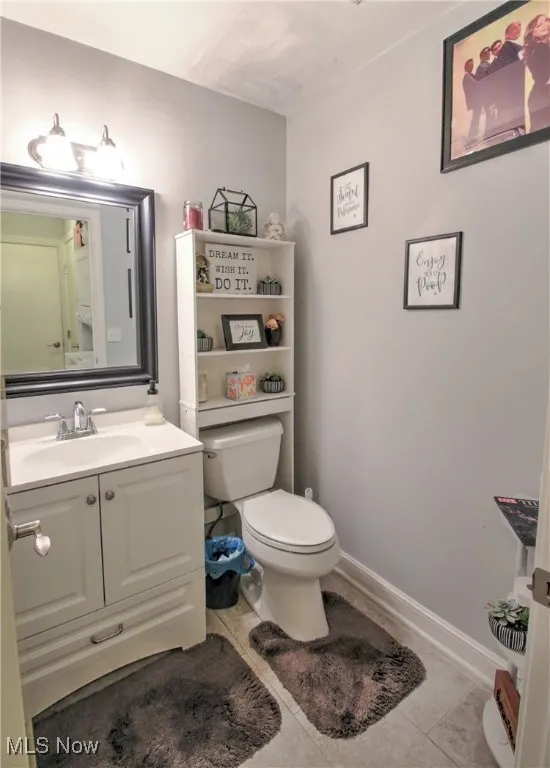 Half bathroom featuring vanity and tile patterned flooring