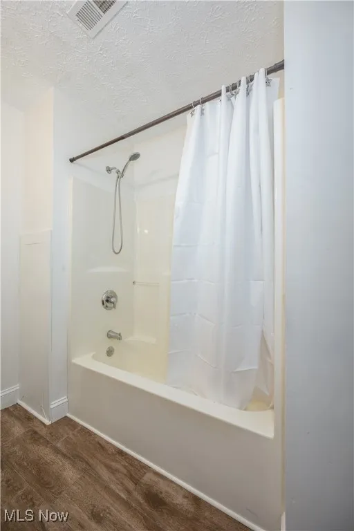 Full bathroom with shower / bath combo with shower curtain, LVT finished floors