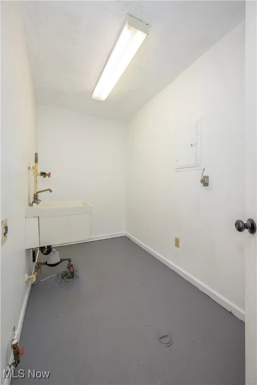 Laundry area featuring baseboards and electric panel