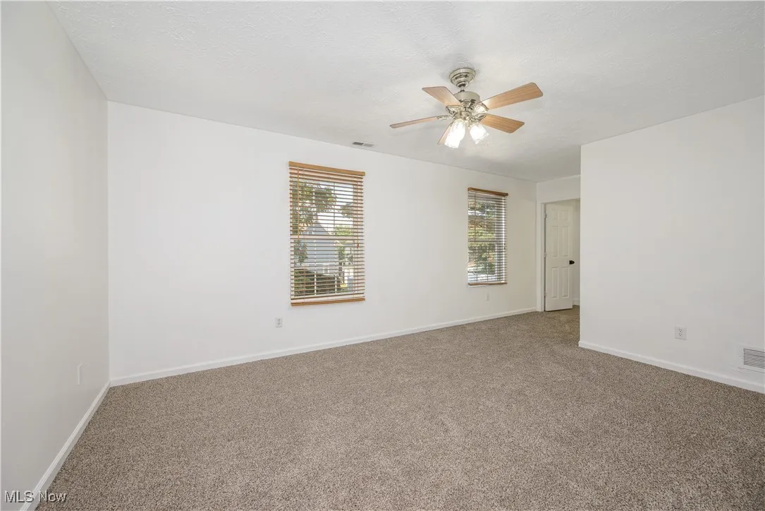 Primary bedroom with a ceiling fan