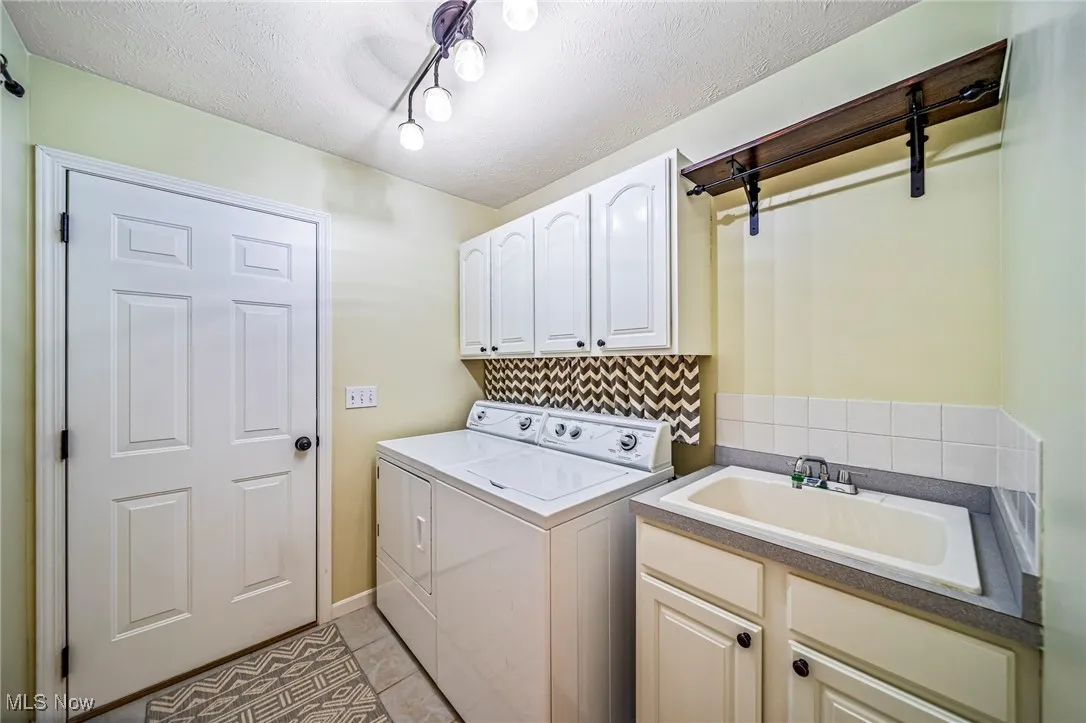 Laundry room featuring cabinet space/shelving and a built in utility sink with storage.