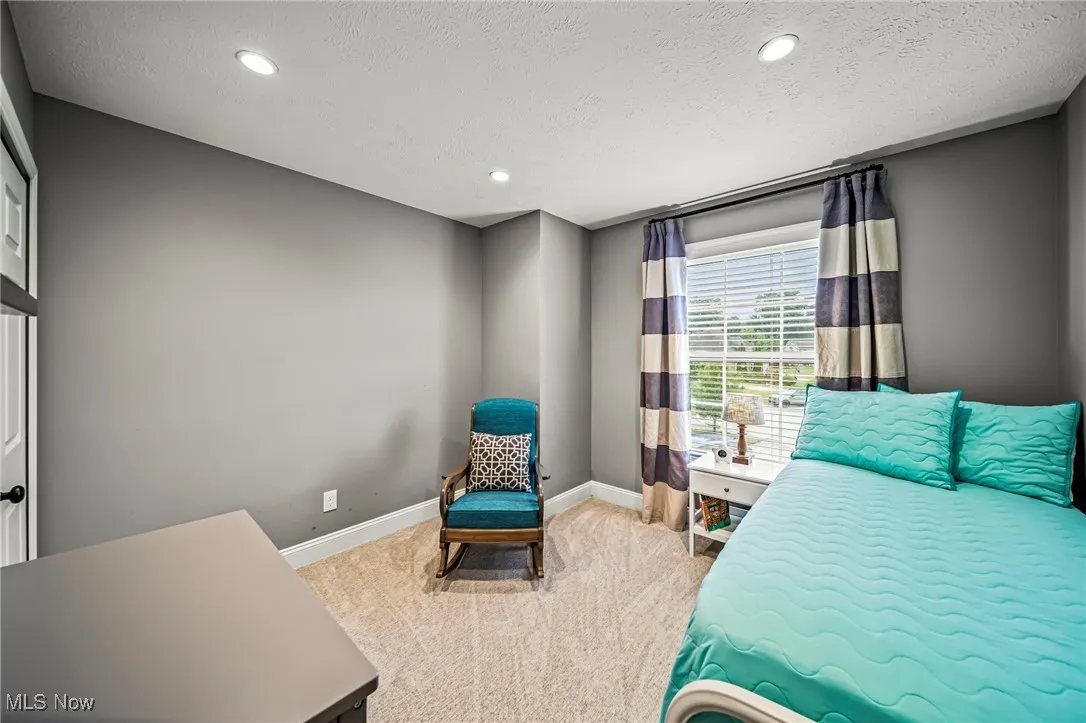 Bedroom #2 with recessed lighting and large front window.