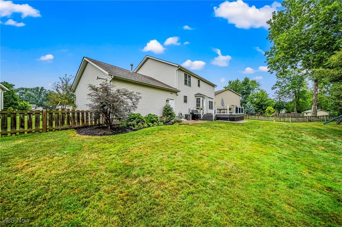 Rear view of house featuring a fully fenced in backyard.