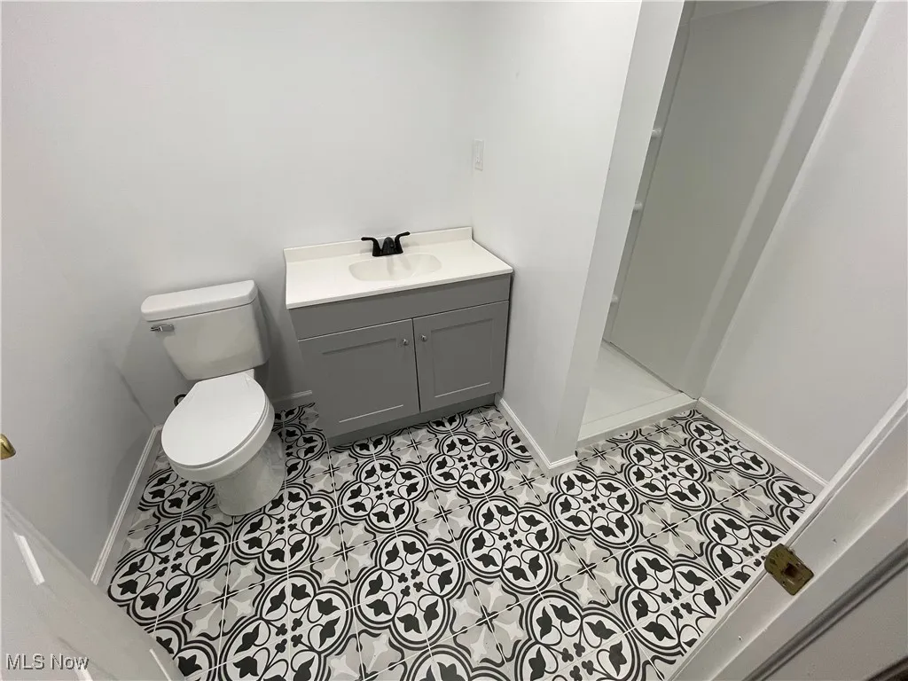 Bathroom featuring a stall shower, vanity, and tile patterned flooring