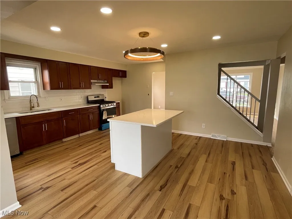 Kitchen with stainless steel appliances, light countertops, recessed lighting, light wood-style flooring, and​​‌​​​​‌​​‌‌​‌‌​​​‌‌​‌​‌​‌​​​‌​​ backsplash