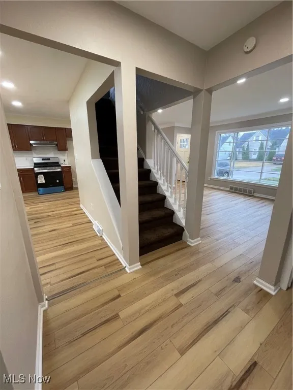 Staircase featuring recessed lighting and wood finished floors