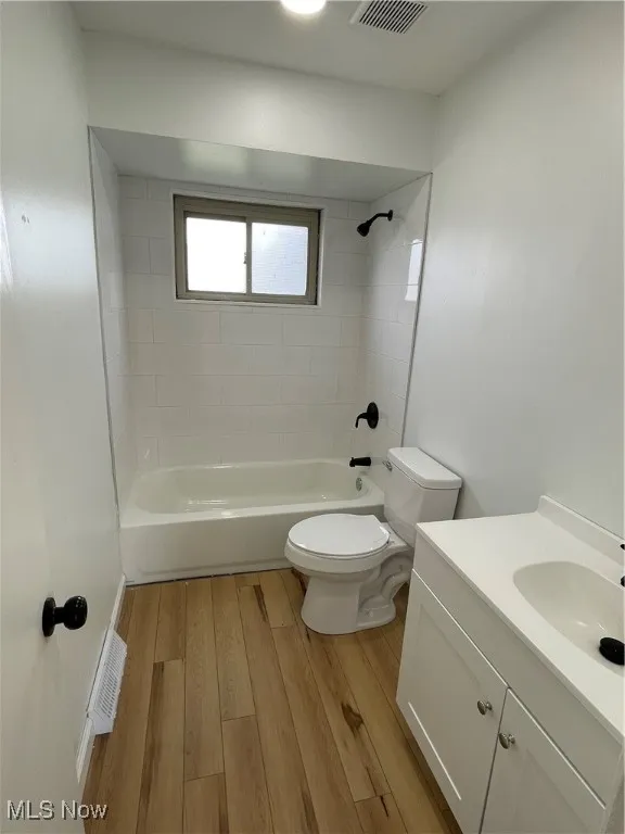 Full bath featuring wood finished floors, vanity, and tub / shower combination