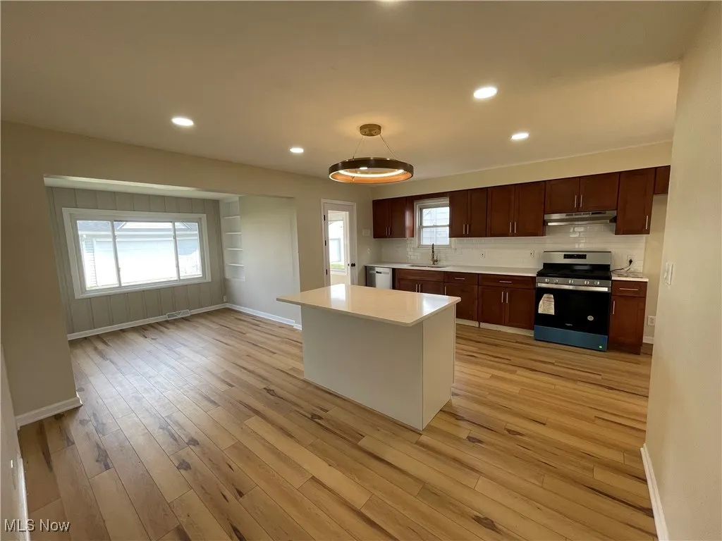 Kitchen with stainless steel range with electric cooktop, recessed lighting, light countertops, healthy amount of natural light, and light wood-type flooring