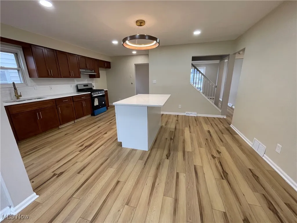 Kitchen featuring stainless steel range oven, light wood-style floors, plenty of natural light, light countertops, and recessed lighting