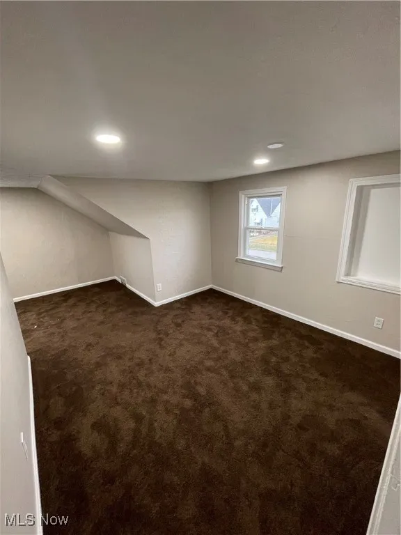Below grade area with dark carpet and recessed lighting