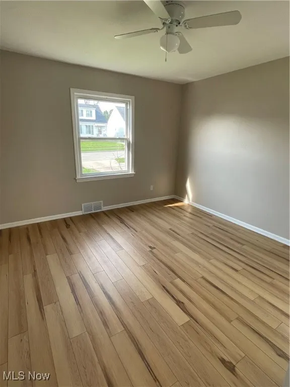 Spare room with light wood-type flooring and ceiling fan