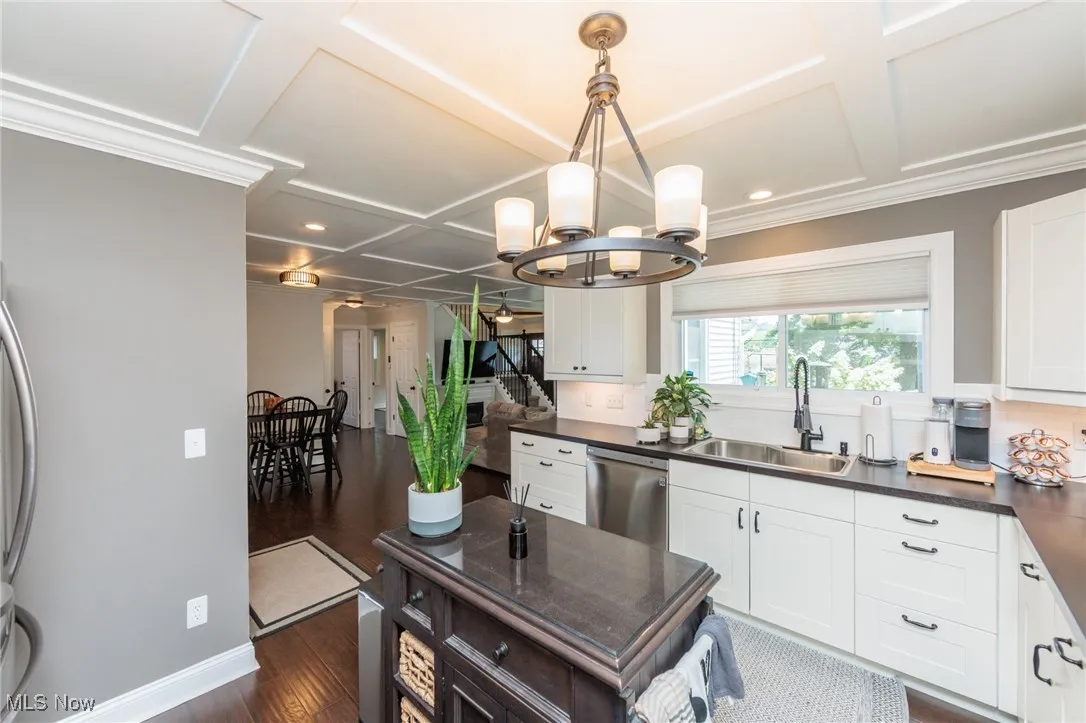 Kitchen featuring dark wood-style flooring, coffered ceiling, a chandelier, recessed lighting, and white cabinets