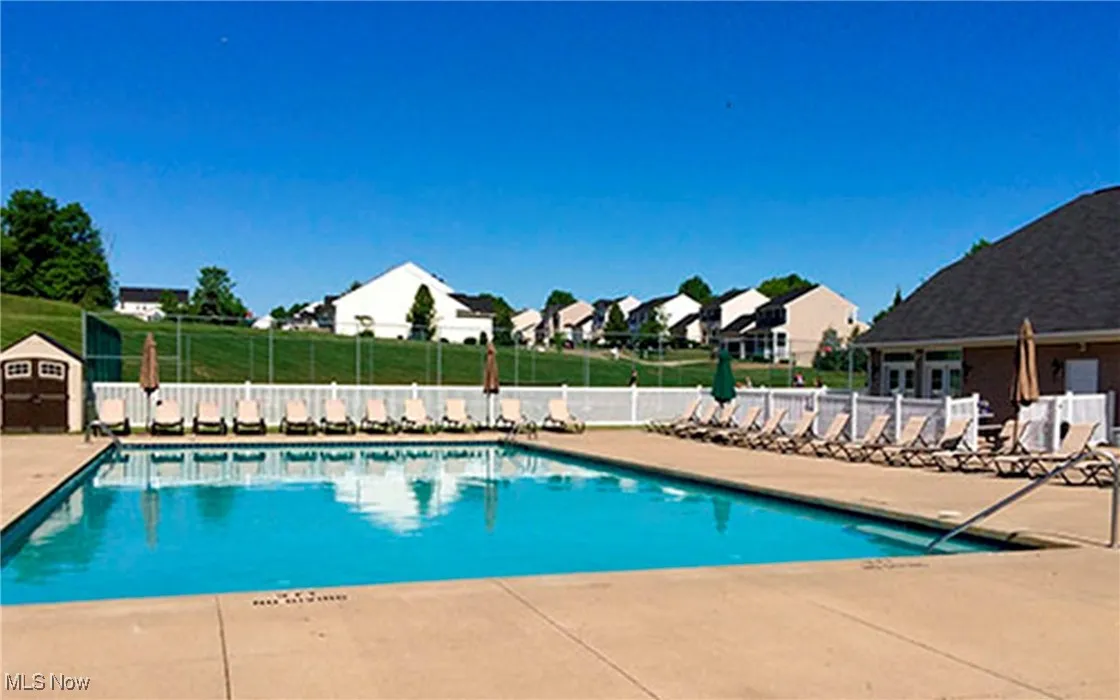 Community pool with a patio and a residential view