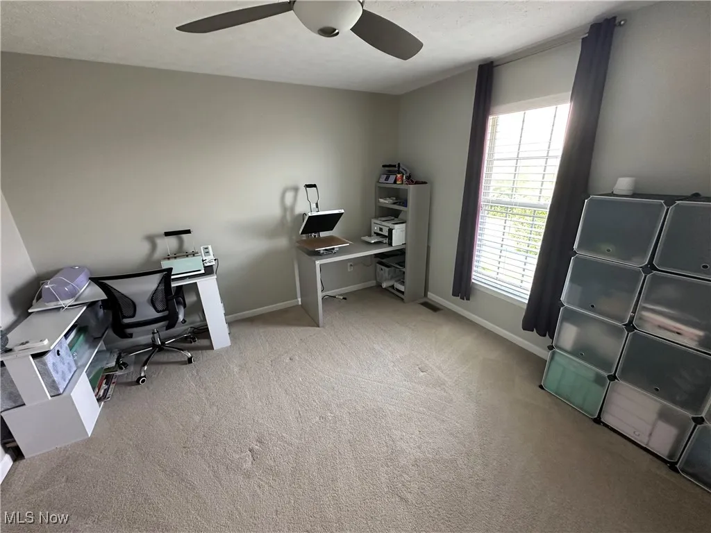 Bedroom featuring light carpet, a textured ceiling, and ceiling fan