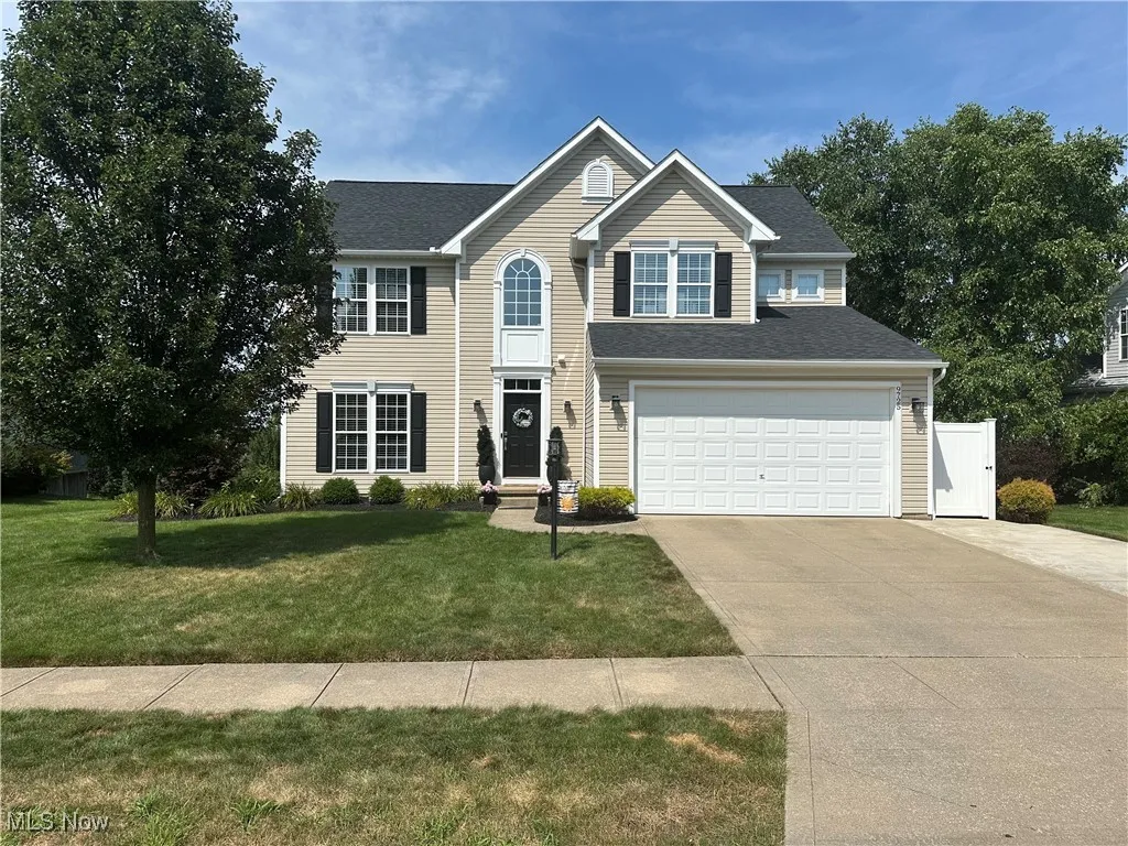 View of front facade featuring driveway, a garage, and a shingled roof