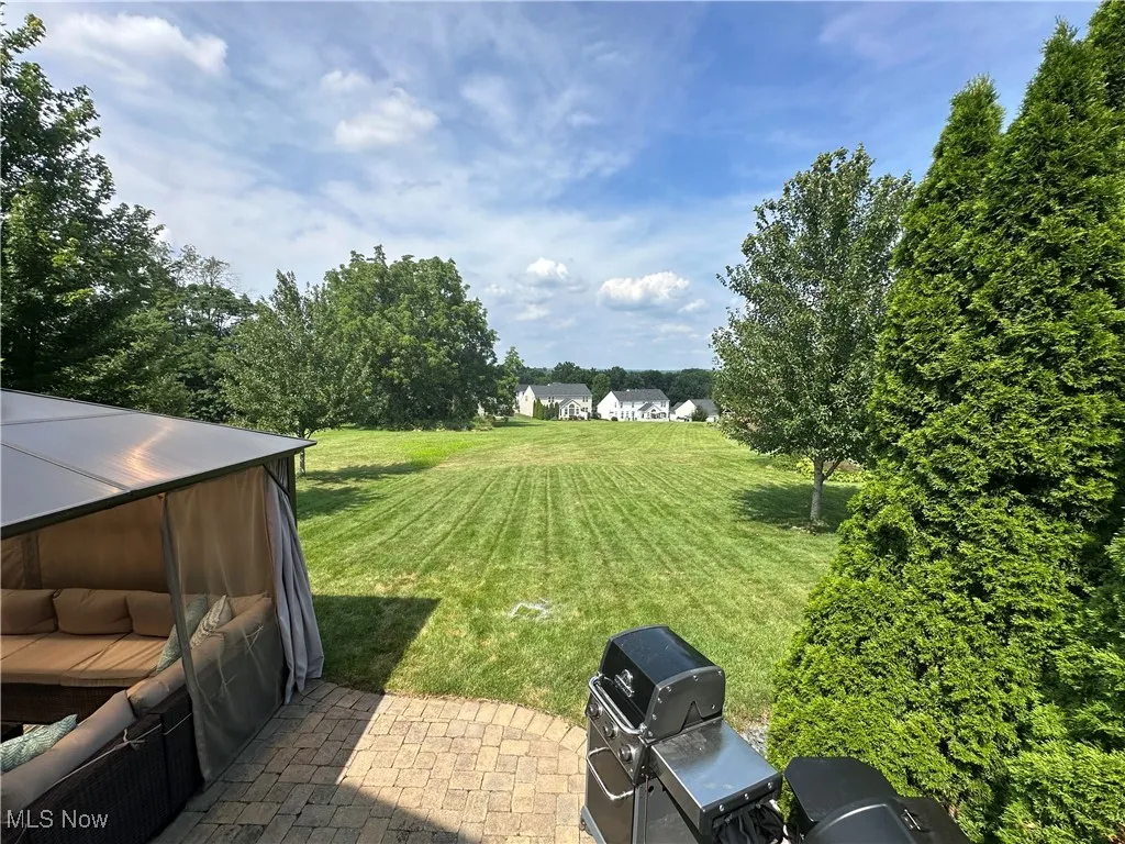 View of green lawn with a patio area