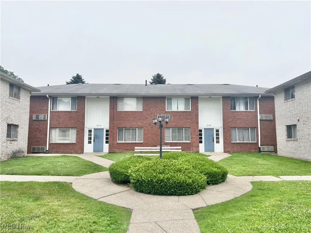 View of front facade with brick siding and a front lawn