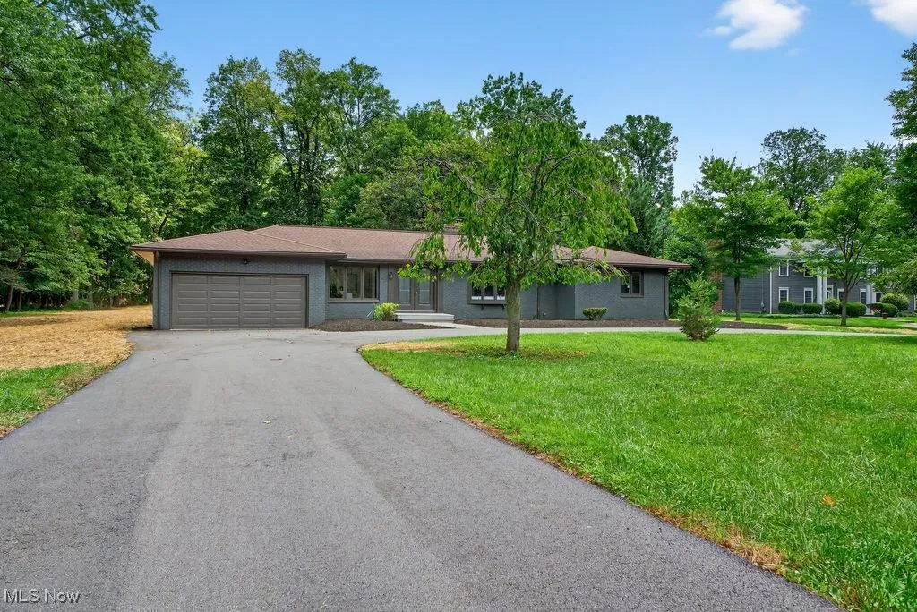 Ranch-style house with a garage, driveway, and a front yard