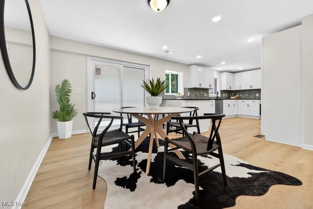 Dining room with light wood finished floors, recessed lighting, and a textured ceiling