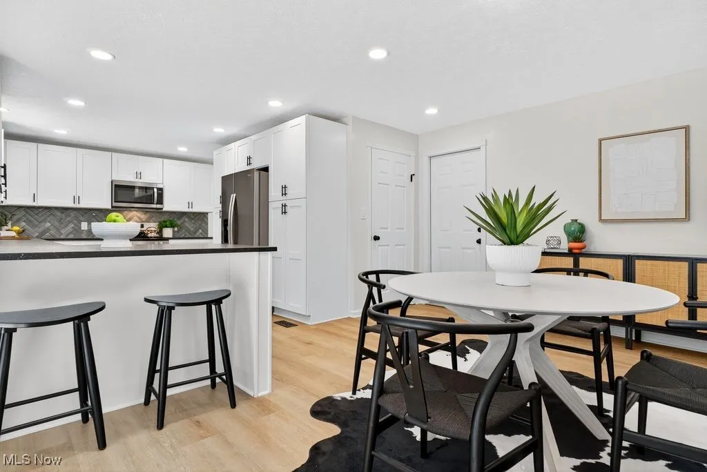 Dining space featuring light wood finished floors and recessed lighting