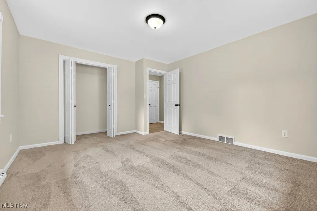 Unfurnished bedroom with carpet floors and baseboards