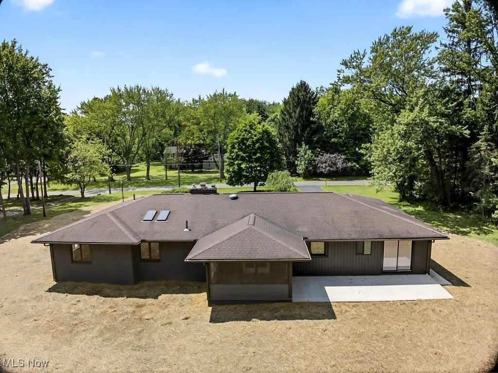 View of subject property with a tree filled landscape