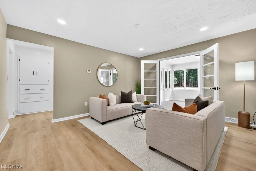 Living area with light wood finished floors, recessed lighting, and a textured ceiling