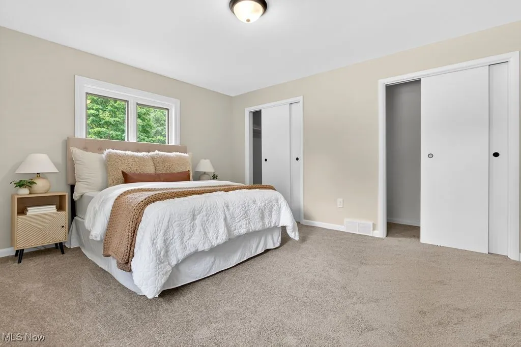 Main en-suite bedroom featuring two closets and baseboards