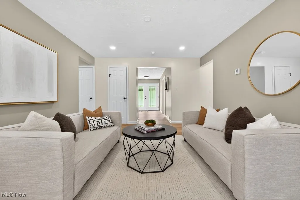 Living area with light wood-style flooring, recessed lighting, and french doors