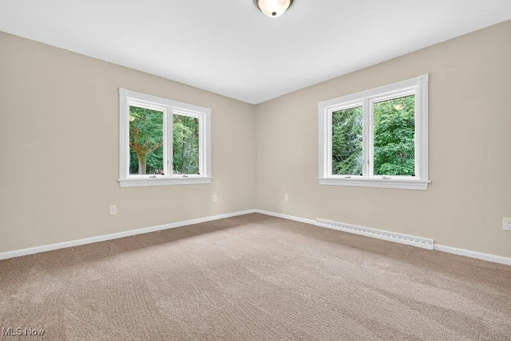 Unfurnished room with healthy amount of natural light, carpet flooring, and baseboard heating