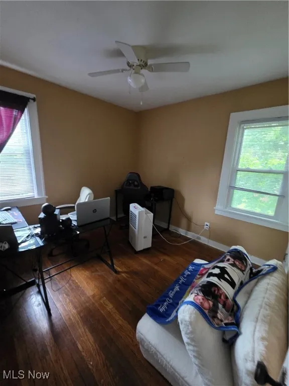 Bedroom with multiple windows, wood-type flooring, ceiling fan, and a desk