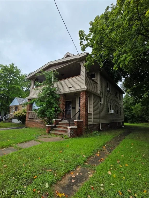 View of front facade featuring a front lawn and brick siding