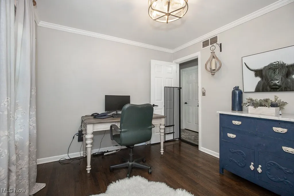Office area featuring ornamental molding and dark wood-type flooring